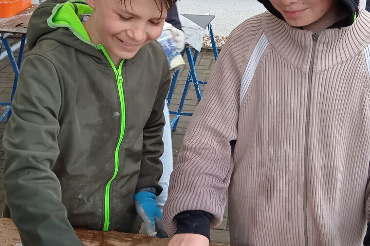 Kinder stellen das Mosaik "Sonne" dar
